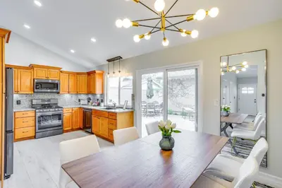 a kitchen with a wooden table and white chairs at Idyllic Tustin Home with Private Patio and Grill in Tustin