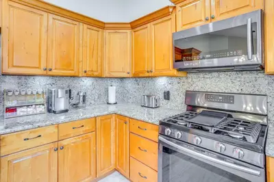 a kitchen with wooden cabinets and stainless steel appliances at Idyllic Tustin Home with Private Patio and Grill in Tustin