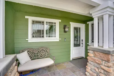 a green house with a chair on a porch at Lovely Tustin Home with Outdoor Kitchen 3 Mi to Zoo in Tustin