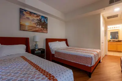 a hotel room with two beds and a bathroom at Urban Haven at Orsini in Los Angeles