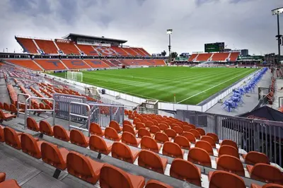 an empty stadium with orange seats and a soccer field at Gramercy Getaway in Los Angeles