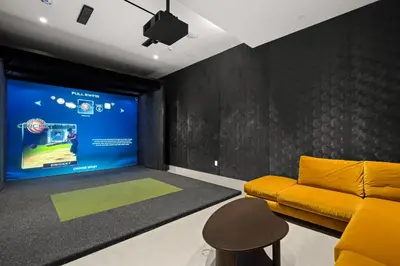 a living room with a yellow couch and a screen at Brand New Modern & Luxury Residence in DTLA in Los Angeles