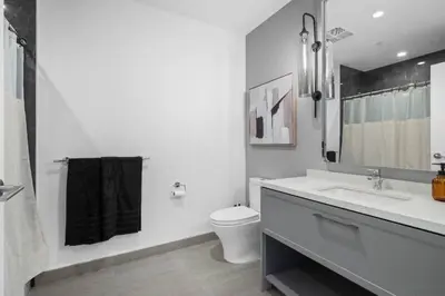 a white bathroom with a sink and a toilet at Epitome of Luxury Condo in DTLA in Los Angeles