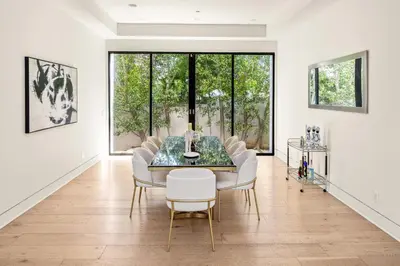 a dining room with a glass table and white chairs at Luxurious Retreat - Modern House with Pool in Los Angeles