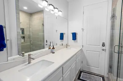 a white bathroom with two sinks and a mirror at Modern Lakefront Dream Home Steps from Big Bear Village in Big Bear Lake