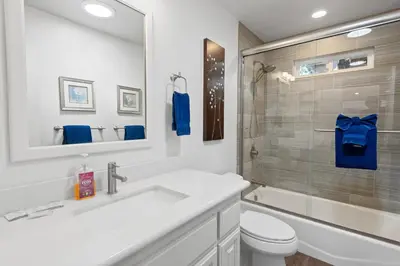 a bathroom with a sink and a toilet and a mirror at Modern Lakefront Dream Home Steps from Big Bear Village in Big Bear Lake