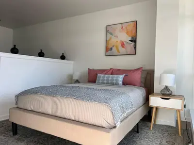 a bedroom with a large bed with pink pillows at Fortuna-Seaside Retreat in Santa Monica, steps to the beach, free parking in Los Angeles