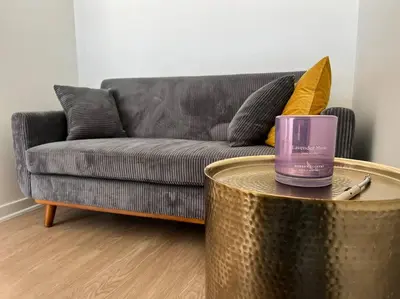 a living room with a couch and a candle on a table at Fortuna-Seaside Retreat in Santa Monica, steps to the beach, free parking in Los Angeles