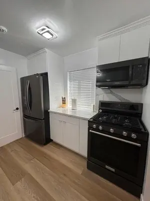 a kitchen with a black stove and a refrigerator at Modern 2BR Stylish & Cozy Unit in Los Angeles