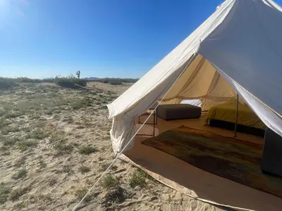 a white tent in the middle of a field at New Yurt City in Lake Los Angeles