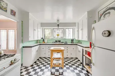 a kitchen with white cabinets and a checkered floor at 2 Blocks to Melrose Ave! Home with Furnished Patio in Los Angeles