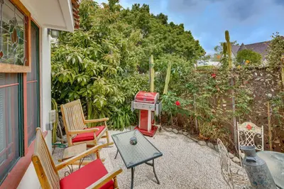 a backyard with chairs and a grill on a patio at 2 Blocks to Melrose Ave! Home with Furnished Patio in Los Angeles