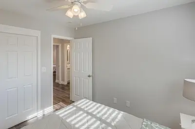 a white room with a ceiling fan and a bed at Bakersfield Home with Pool Table, Cornhole and More! in Bakersfield