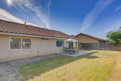 a house with a table and chairs in a yard at Bakersfield Home with Pool Table, Cornhole and More! in Bakersfield
