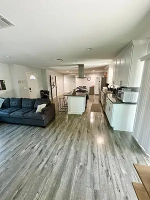 a living room with a couch and a kitchen at Cheers Hostel in Los Angeles
