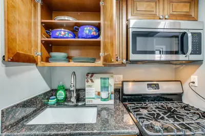 a kitchen with a sink and a microwave at Anaheim Studio with Fireplace 14 Mi to Disneyland! in Anaheim