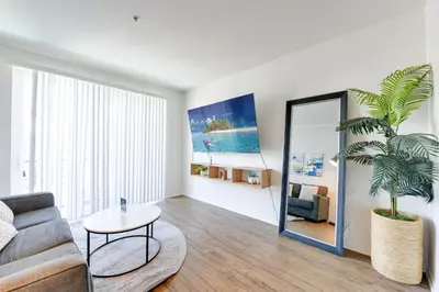 a living room with a couch and a mirror at Cozy Unit Conveniently Located Pool View in Los Angeles