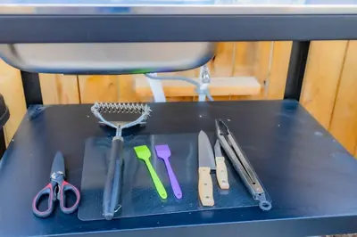 a table with several different kitchen utensils on it at Urban Oasis Luxe Glamping with King Bed & BBQ in Glendora