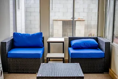 two chairs and a table with blue pillows on a balcony at Peaceful Family Home with 3 Bedrooms and 2 Bathrooms in Glendora