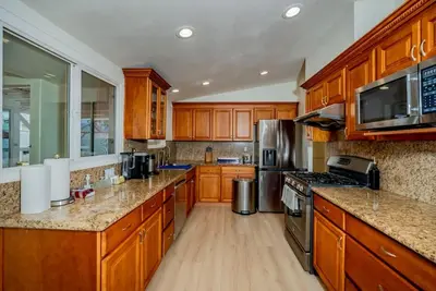 a large kitchen with wooden cabinets and stainless steel appliances at Peaceful Family Home with 3 Bedrooms and 2 Bathrooms in Glendora