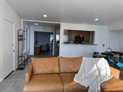 a living room with a brown couch and a kitchen at 30 PCT OFF!! Limited Time! Malibu Ocean Wave with King Bed, Walking to Beach and Hiking in Malibu