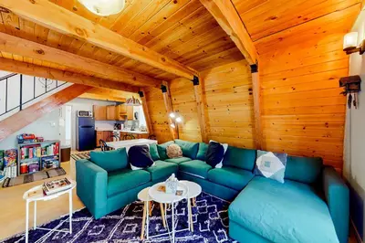 a living room with a green couch and a table at Hidden Wonder in Crestline