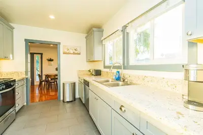 a kitchen with white cabinets and a sink at Newly Remodeled 3B2B House in Glendora