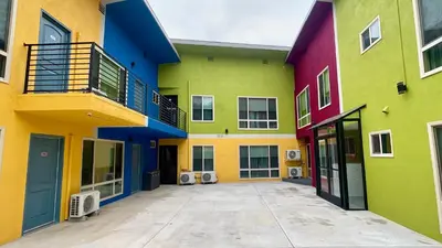 a group of brightly colored buildings with a courtyard at Quintessence ApartHotel in Los Angeles