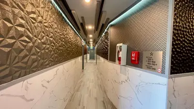 a long hallway with tiles on the walls at Quintessence ApartHotel in Los Angeles