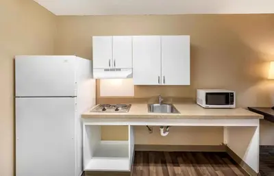 a kitchen with a sink and a white refrigerator at Relax Suites Extended Stay - La Mirada in La Mirada