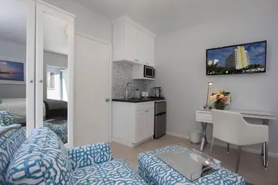 a living room with a couch and a table and a kitchen at Beautiful renovated studio close to ocean! in Los Angeles