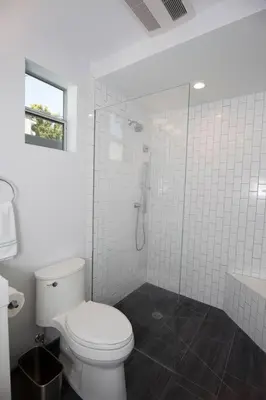 a white bathroom with a toilet and a shower at Beautiful renovated studio close to ocean! in Los Angeles