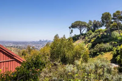 a hill with trees and a red building on it at Hollywood Hills Retreat w Sweeping Views 2 Bd 2 Bt in Los Angeles