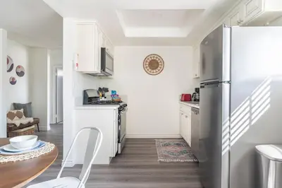a kitchen with a stainless steel refrigerator and a table at Enjoy Alhambra Night Life at 2BR Apt in Alhambra