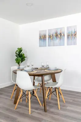 a dining room table with white chairs and a painting at City Retreat Minutes to DT in Alhambra