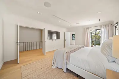 a white bedroom with a bed and a television at Bella Villa in Los Angeles