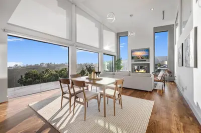 a dining room with a table and chairs and a fireplace at Summitridge in Los Angeles