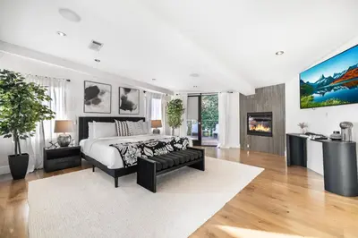 a white bedroom with a bed and a fireplace at Summitridge in Los Angeles