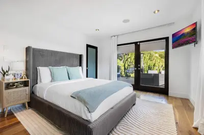 a bedroom with a large bed and a sliding glass door at Summitridge in Los Angeles