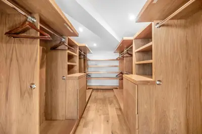 a walk in closet with wooden doors and shelves at Summitridge in Los Angeles