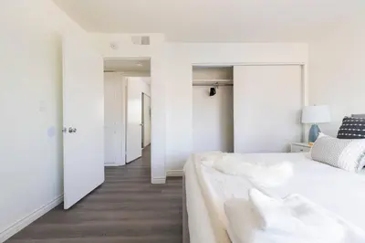 a white bedroom with a large bed and a hallway at Modern 2BR Condo with King Bed & Balcony near LA in Alhambra