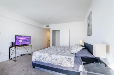 a bedroom with a bed and a flat screen tv at Hollywood Furnished Apartments in Los Angeles