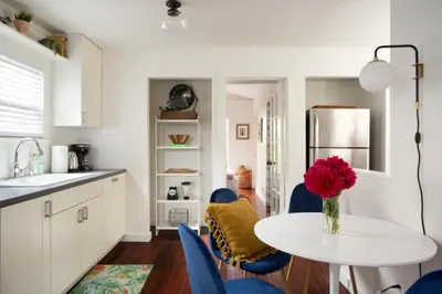 a kitchen with a table with a vase of flowers on it at Stylish 2bed 2bath Culver Cottage with bicycles in Los Angeles