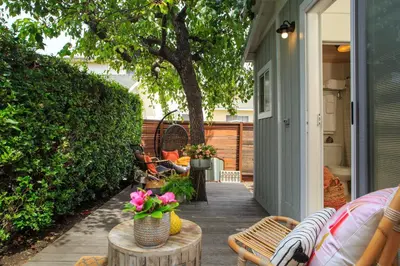 a patio with chairs and a table with flowers on it at Stylish 2bed 2bath Culver Cottage with bicycles in Los Angeles