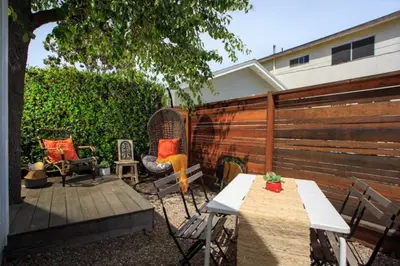 a backyard with chairs and a table and a fence at Stylish 2bed 2bath Culver Cottage with bicycles in Los Angeles