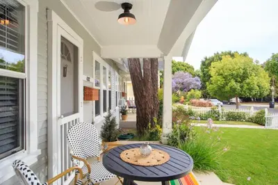 a porch with a table and chairs on a house at Stylish 2bed 2bath Culver Cottage with bicycles in Los Angeles