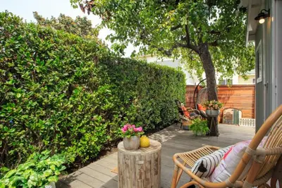 a patio with chairs and a table and a tree at Stylish 2bed 2bath Culver Cottage with bicycles in Los Angeles