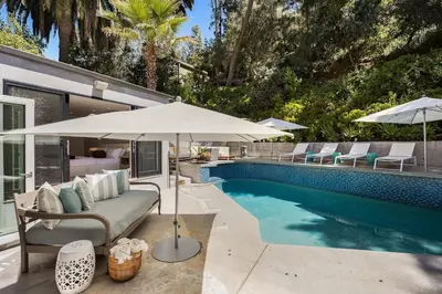 a patio with an umbrella and a swimming pool at Beverly Hills Canyon Villa by Stay Awhile Villas in Los Angeles