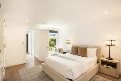 a white bedroom with a large bed and a chair at Beverly Hills Canyon Villa by Stay Awhile Villas in Los Angeles