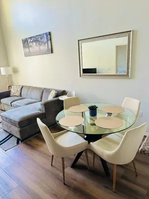 a living room with a glass table and chairs at Spacious,2Queen beds, free parking, pool&gym and central location in Marina del Rey